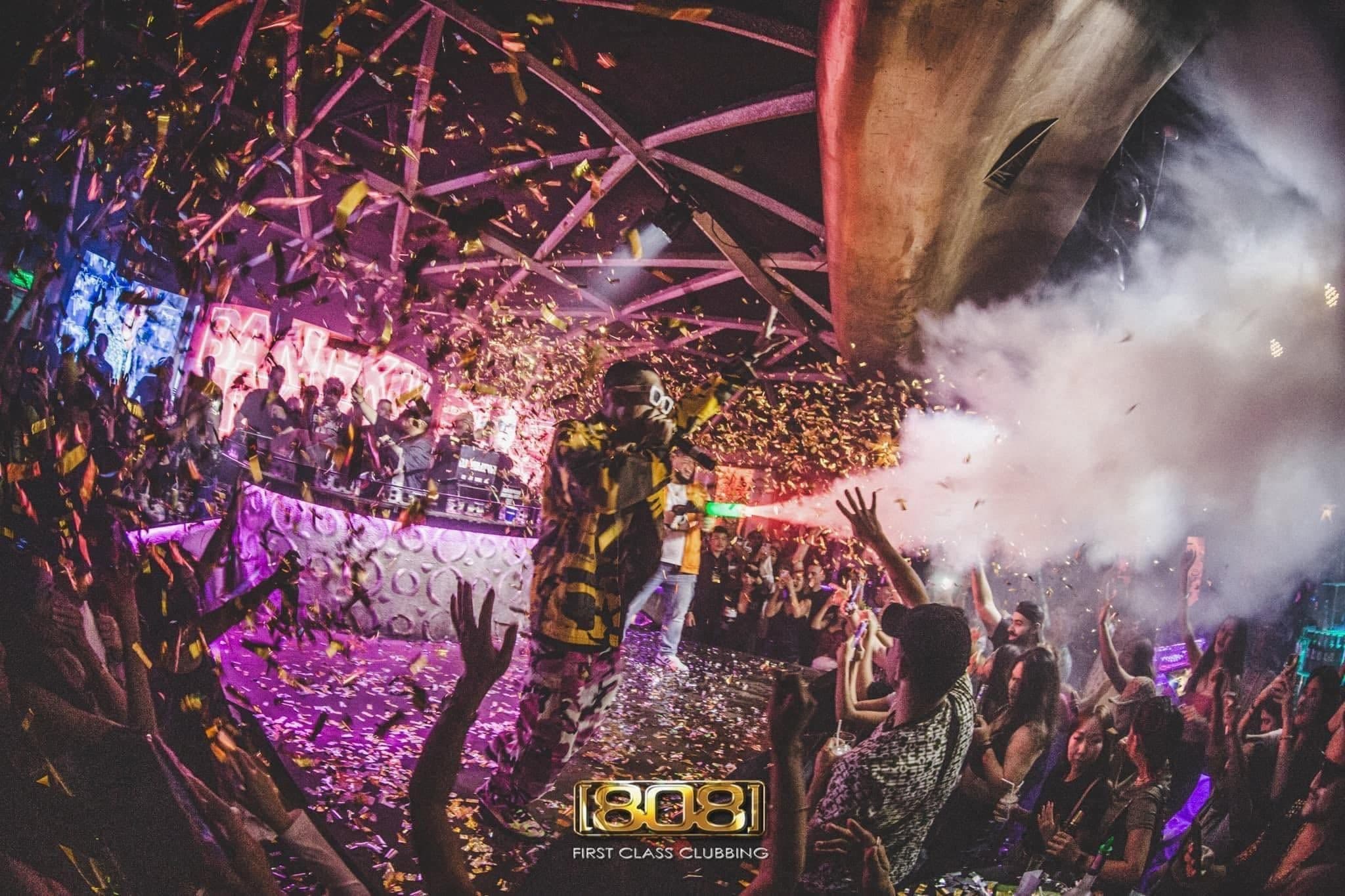 Gold confetti falls over a performer and the crowd at 808